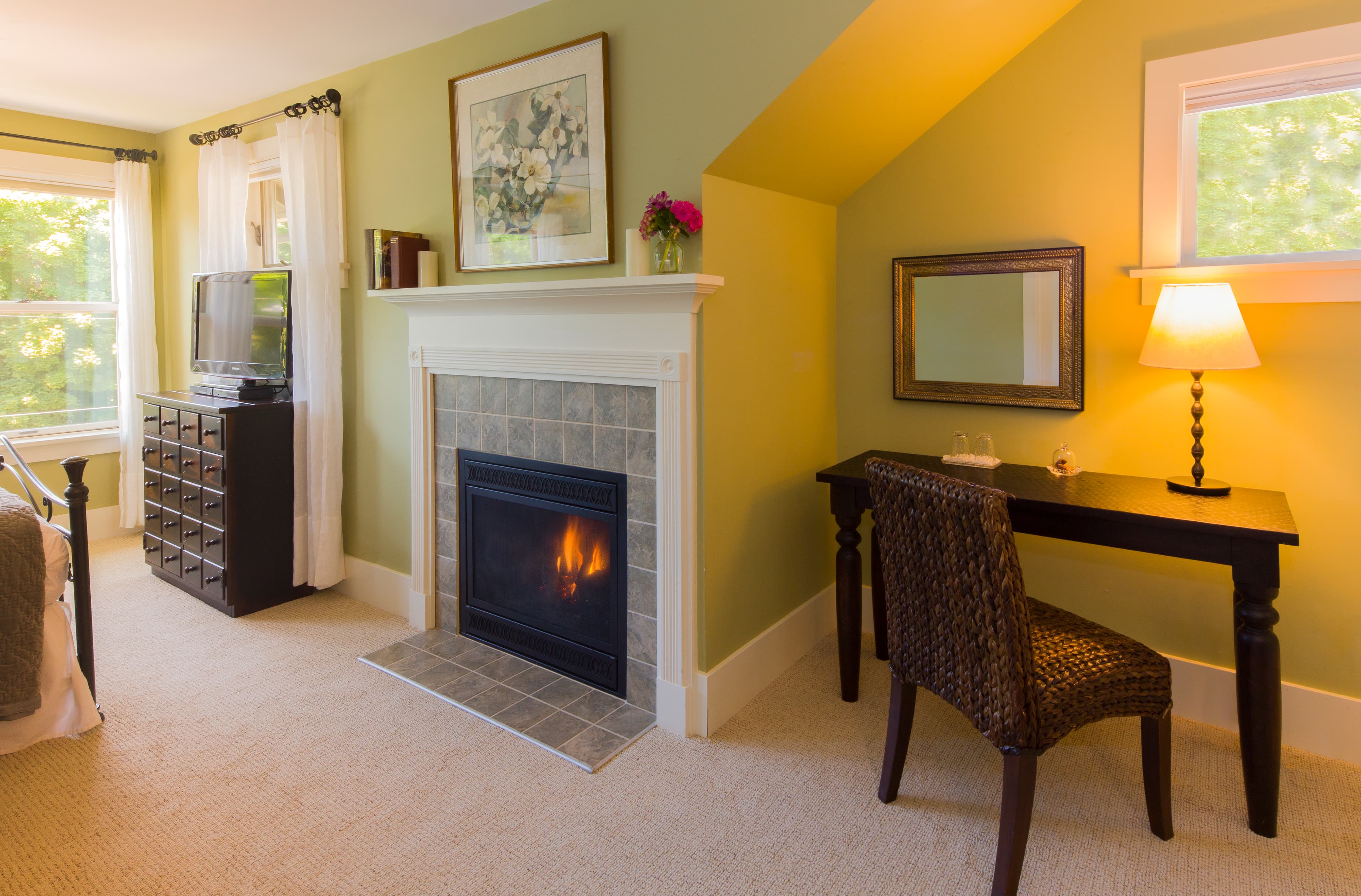 Cozy living room with a lit fireplace, wine glass on a table, and a beige sofa.