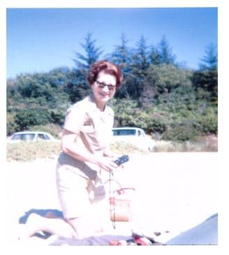 middle aged woman kneeling on beach
