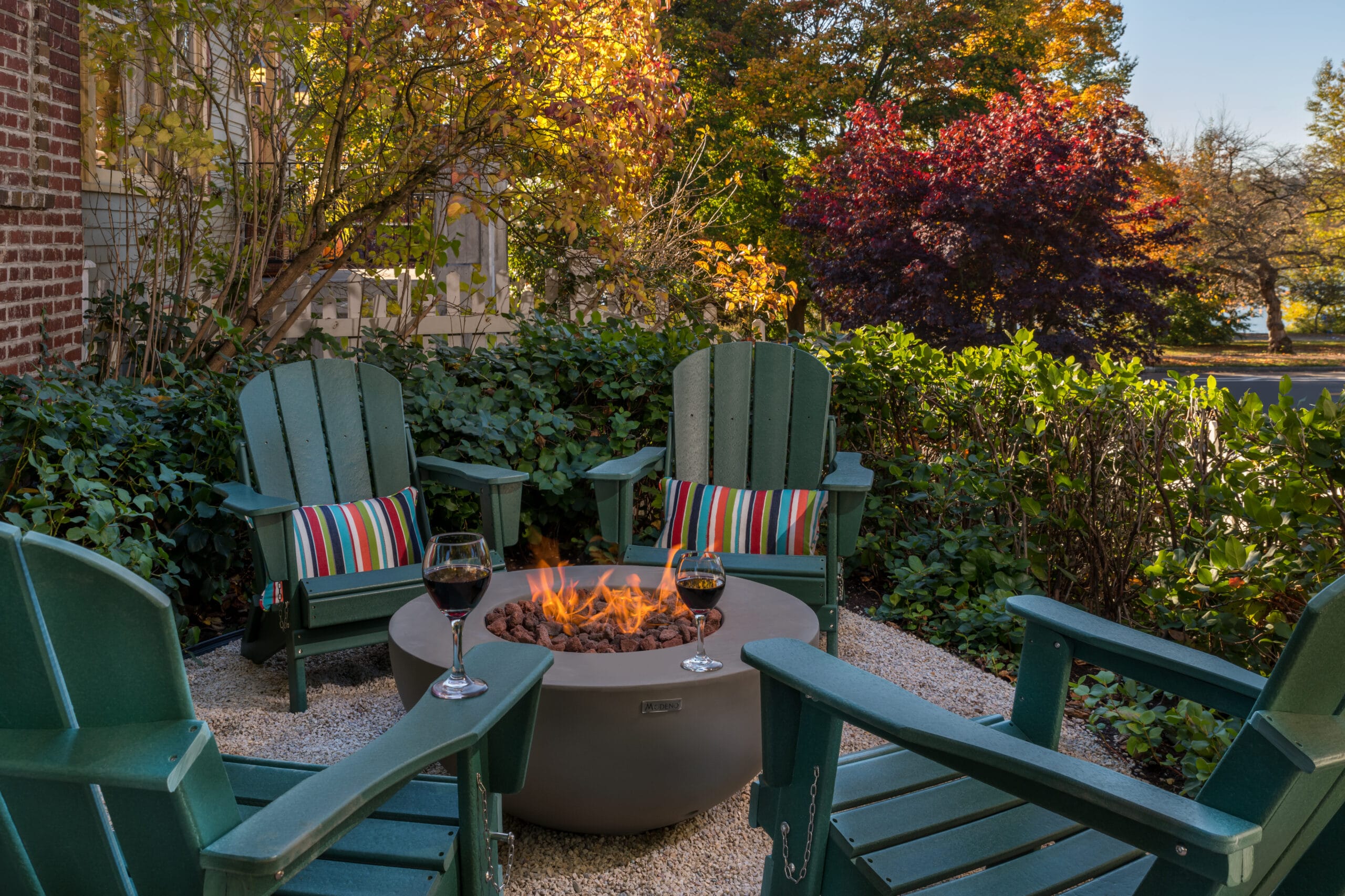 firepit with chairs and trees with fall color