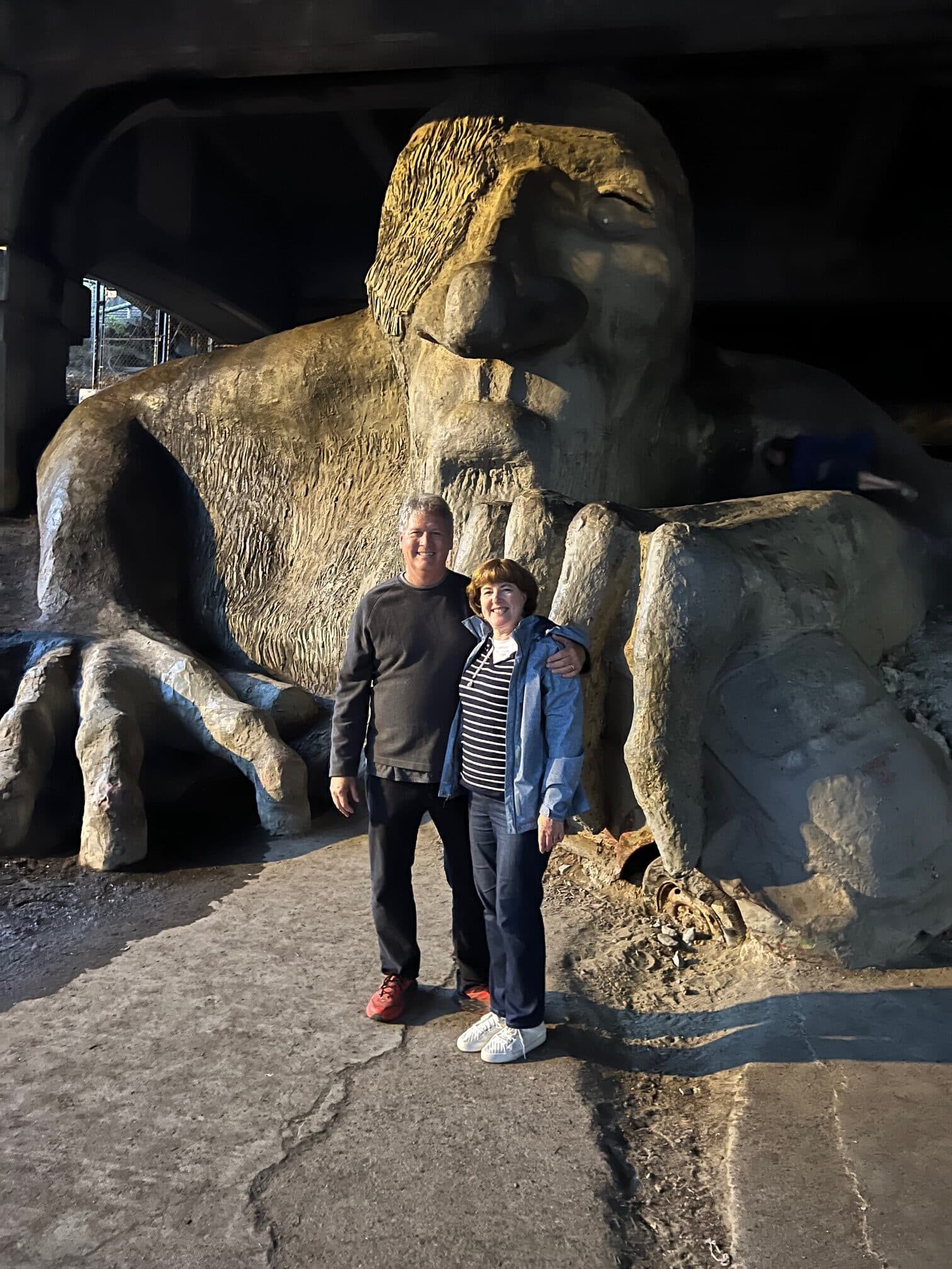 couple standing in front of large Fremont troll sculpture