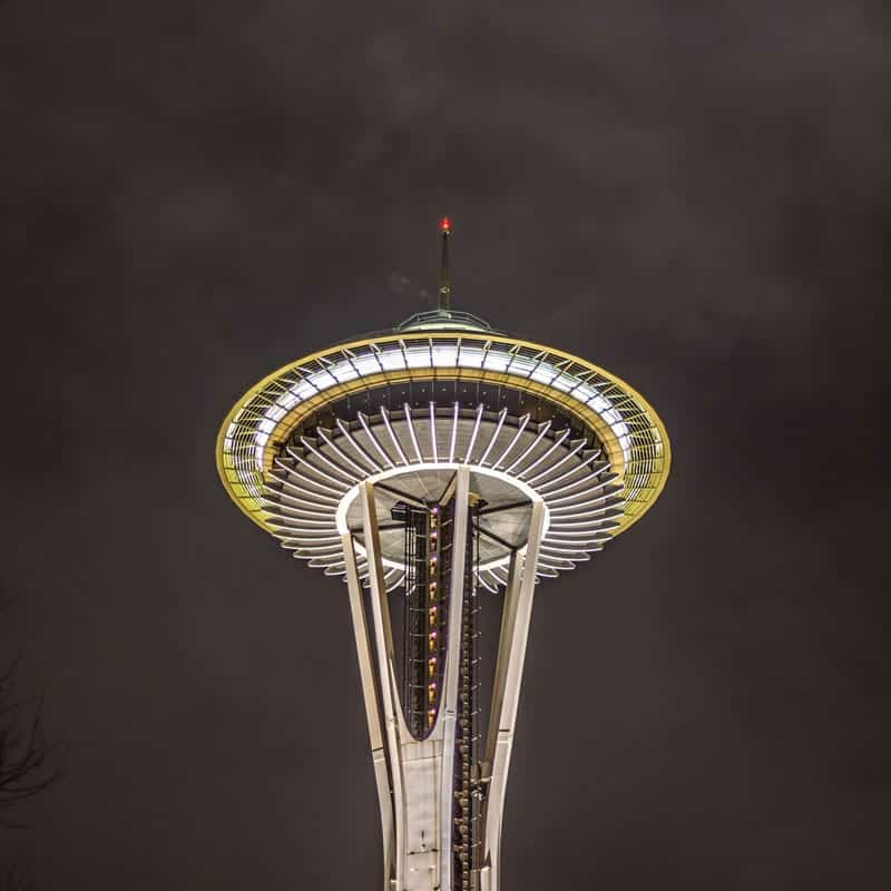 The space needle on a dark night lit up in Seattle green